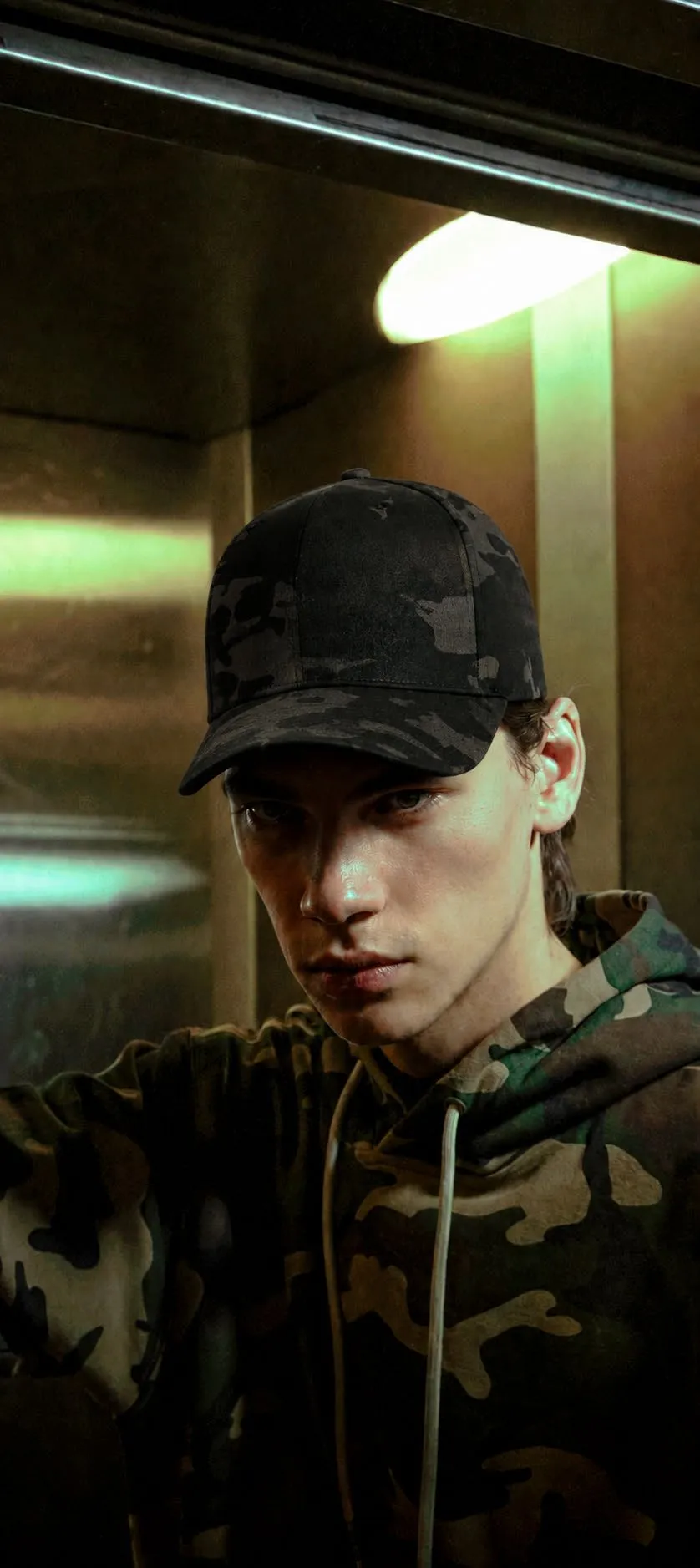 Joven con gorra de camuflaje negro y sudadera camuflada